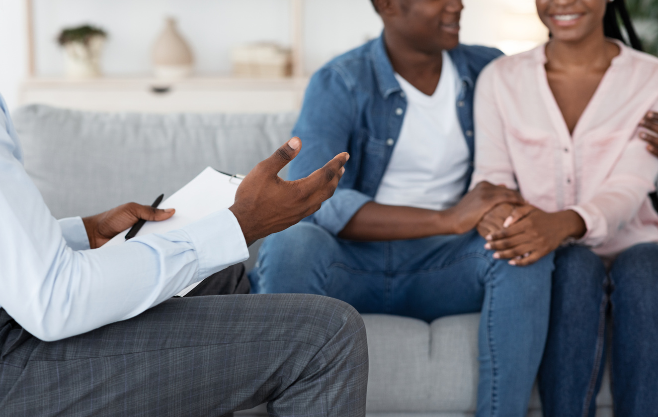 Marriage Counseling. Unrecognizable Black Counselor Talking To Happy Black Couple At Office