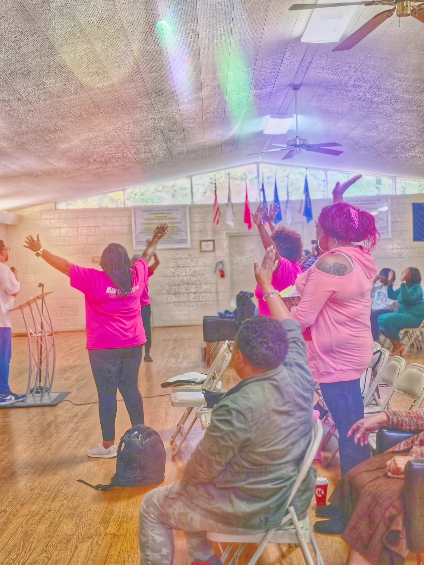 People worshipping with raised hands at The Decision Christian Assembly